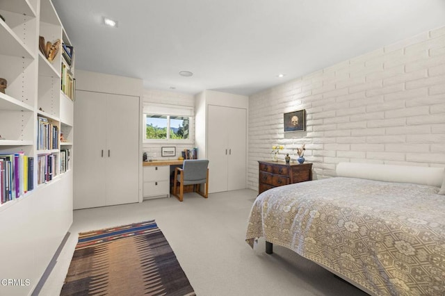 4530 Hendrickson Rd, Ojai, CA 93023 - bedroom with two closets, brick wall, light carpet, and an office area