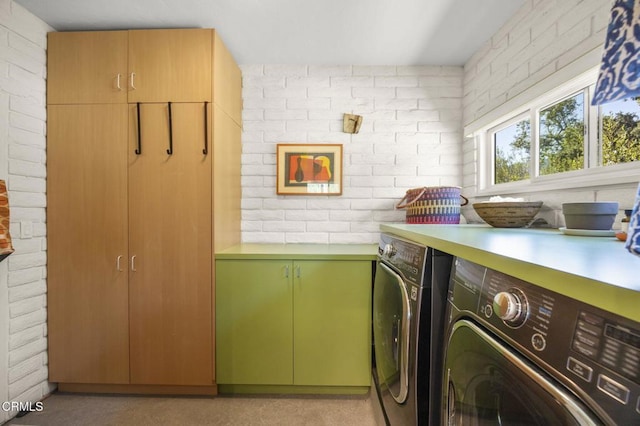 4530 Hendrickson Rd, Ojai, CA 93023 - washroom featuring cabinet space, brick wall, and washing machine and dryer