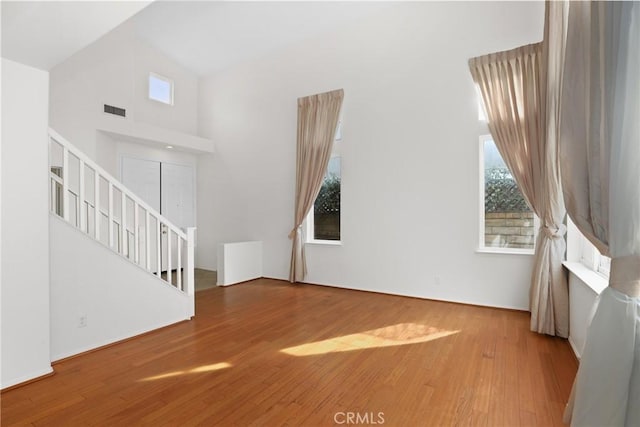 28403 Calex Dr, Valencia, CA 91354 - unfurnished living room with healthy amount of natural light, wood finished floors, a high ceiling, and stairs