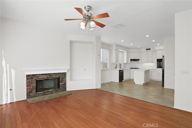 28403 Calex Dr, Valencia, CA 91354 - unfurnished living room featuring light wood-type flooring, ceiling fan, a fireplace, and recessed lighting