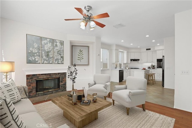 28403 Calex Dr, Valencia, CA 91354 - living area with a ceiling fan, a stone fireplace, recessed lighting, and light wood-style floors