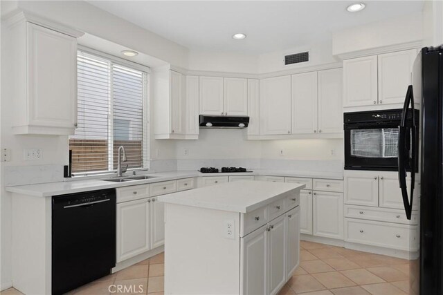28403 Calex Dr, Valencia, CA 91354 - kitchen with black appliances, under cabinet range hood, light tile patterned flooring, white cabinets, and light countertops