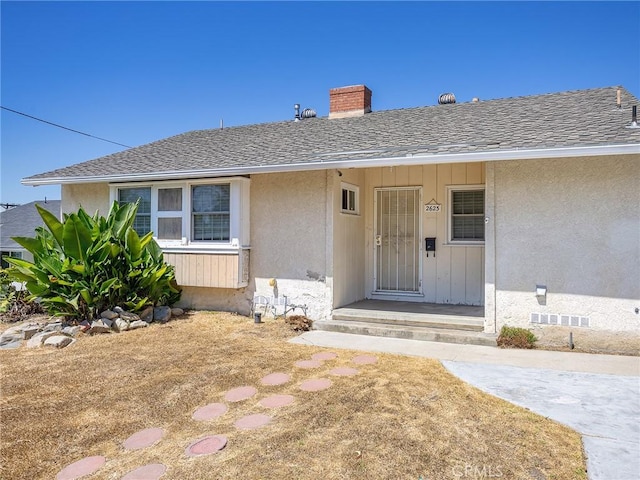 2623 N Parish Pl, Burbank, CA 91504 - property entrance with a chimney, a shingled roof, and stucco siding