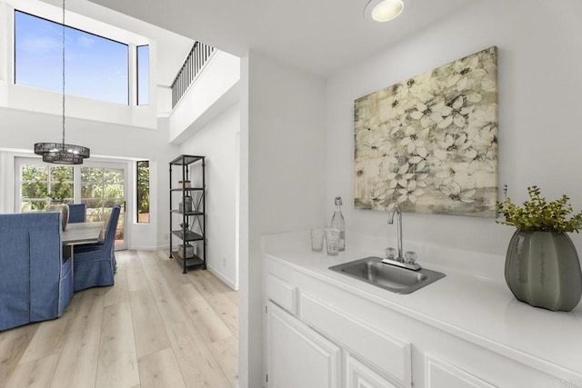 1471 Mercado, Escondido, CA 92026 - kitchen with a chandelier, light countertops, light wood finished floors, white cabinets, and hanging light fixtures