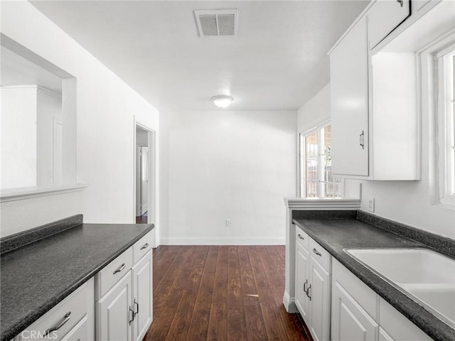 2135 Arden Dr W, Fresno, CA 93703 - kitchen with dark countertops, white cabinetry, and dark wood-style flooring