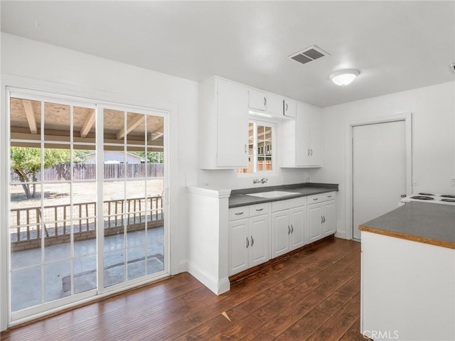 2135 Arden Dr W, Fresno, CA 93703 - kitchen featuring dark countertops, dark wood-style flooring, and white cabinets