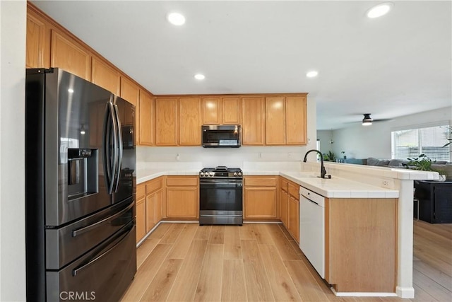 23885 Cheyenne Canyon Dr, Menifee, CA 92587 - kitchen featuring appliances with stainless steel finishes, a peninsula, open floor plan, light wood finished floors, and recessed lighting