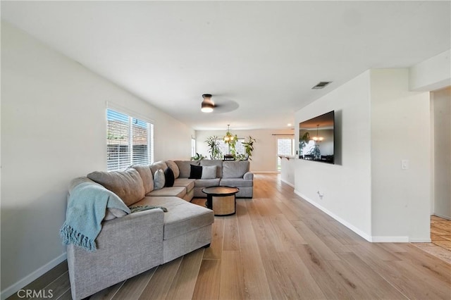 23885 Cheyenne Canyon Dr, Menifee, CA 92587 - living room featuring healthy amount of natural light, light wood-style flooring, and a chandelier