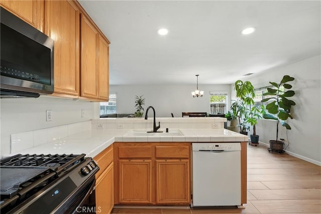 23885 Cheyenne Canyon Dr, Menifee, CA 92587 - kitchen featuring white dishwasher, a peninsula, plenty of natural light, a chandelier, and recessed lighting