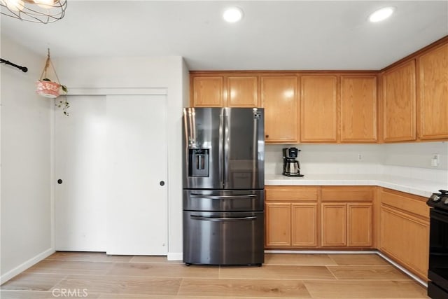 23885 Cheyenne Canyon Dr, Menifee, CA 92587 - kitchen with stainless steel fridge, light wood-style floors, tile counters, recessed lighting, and brown cabinets
