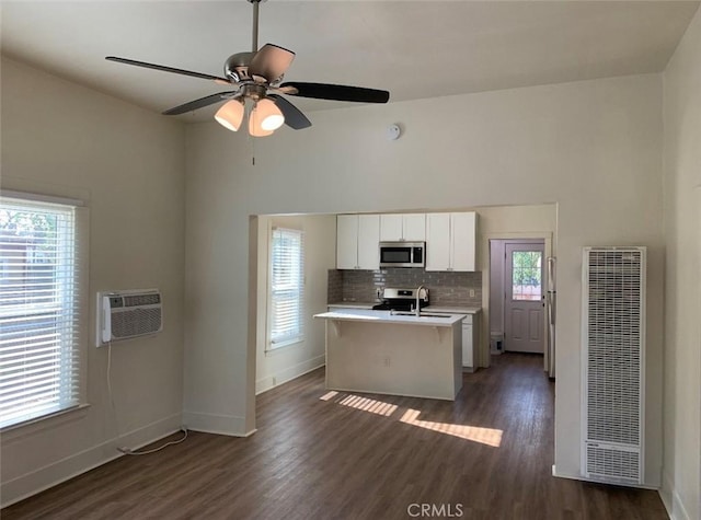 1326 Mulberry St, Chico, CA 95928 - kitchen featuring stainless steel appliances, a heating unit, a wall mounted AC, light countertops, and dark wood-type flooring