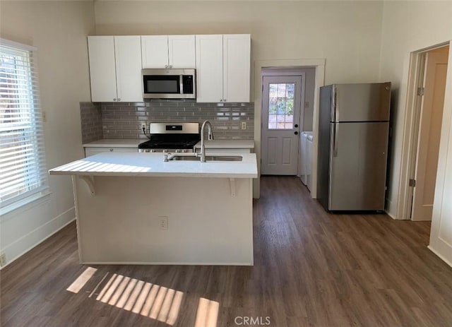 1326 Mulberry St, Chico, CA 95928 - kitchen featuring appliances with stainless steel finishes, light countertops, dark wood-type flooring, white cabinetry, and tasteful backsplash