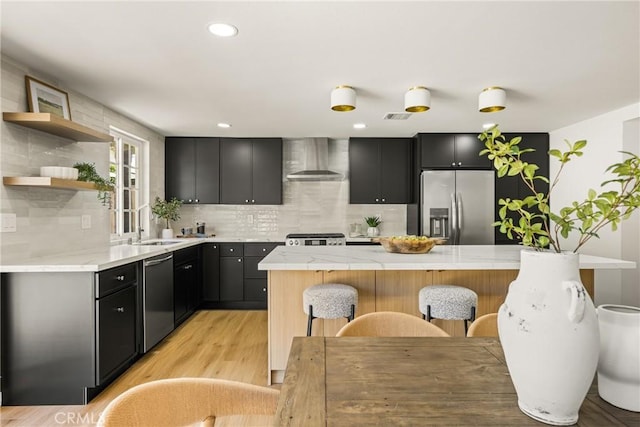 121 W Borromeo Ave, Placentia, CA 92870 - kitchen with appliances with stainless steel finishes, wall chimney exhaust hood, light countertops, decorative backsplash, and a kitchen bar
