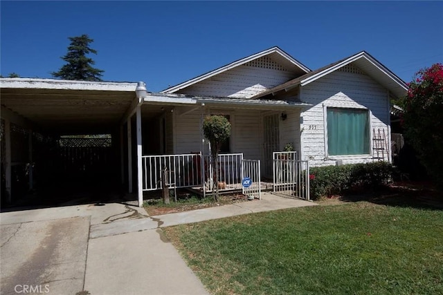 937 E 6th St, Madera, CA 93638 - view of front of house featuring a porch, a front lawn, concrete driveway, and a carport