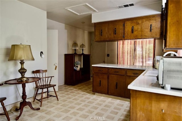937 E 6th St, Madera, CA 93638 - kitchen with light flooring, light countertops, and brown cabinets