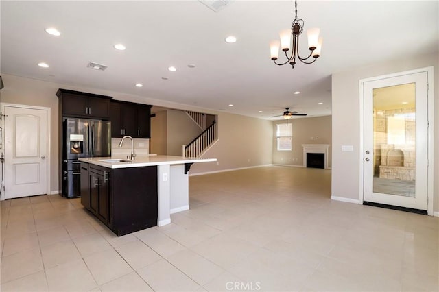 28245 Nield Ct, Saugus, CA 91350 - kitchen with refrigerator with ice dispenser, light countertops, a center island with sink, a fireplace, and open floor plan