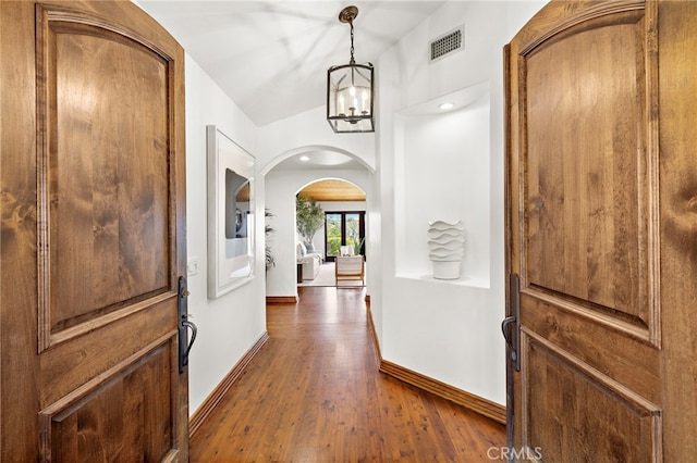 2575 Temple Hills Dr, Laguna Beach, CA 92651 - foyer entrance with arched walkways, dark wood finished floors, and a chandelier