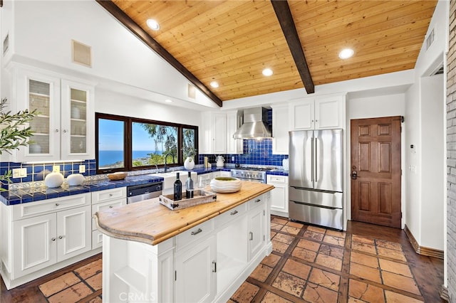 2575 Temple Hills Dr, Laguna Beach, CA 92651 - kitchen with appliances with stainless steel finishes, wall chimney exhaust hood, white cabinets, tasteful backsplash, and a wooden ceiling with exposed beams