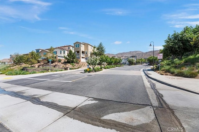 7346 Garnet Ridge Rd, Jurupa Valley, CA 92509 - view of asphalt street featuring a residential view, street lighting, curbs, and sidewalks