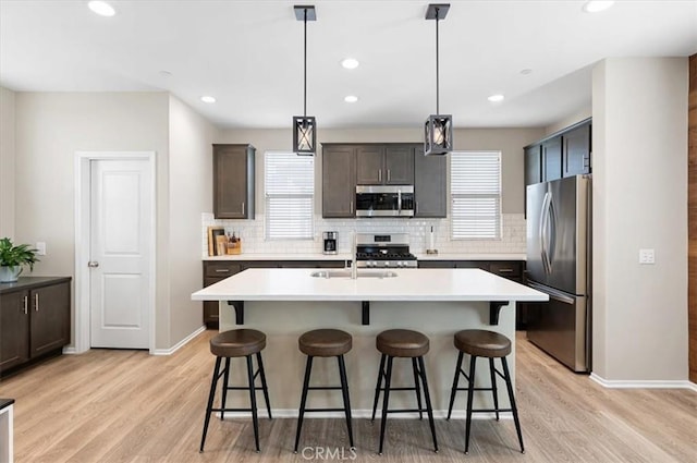 7346 Garnet Ridge Rd, Jurupa Valley, CA 92509 - kitchen with appliances with stainless steel finishes, a breakfast bar area, light wood finished floors, and recessed lighting