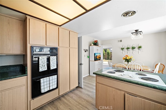 20822 Skimmer Ln, Huntington Beach, CA 92646 - kitchen with light brown cabinetry, white electric stovetop, light wood-style flooring, and dark countertops
