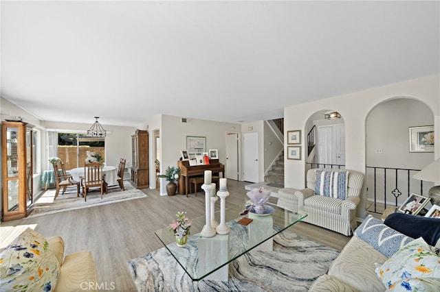 20822 Skimmer Ln, Huntington Beach, CA 92646 - living room featuring light wood finished floors, stairway, and arched walkways