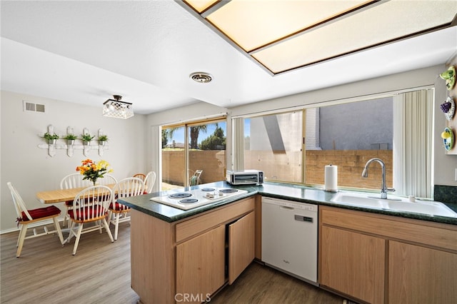 20822 Skimmer Ln, Huntington Beach, CA 92646 - kitchen featuring white appliances, a peninsula, wood finished floors, and dark countertops