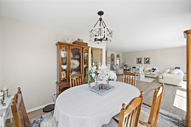 20822 Skimmer Ln, Huntington Beach, CA 92646 - dining area with light wood-style floors, a chandelier, and arched walkways