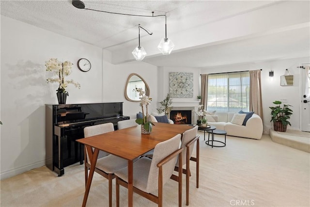 53 Misty Run Unit 10, Irvine, CA 92614 - dining space with a warm lit fireplace, light colored carpet, and a textured ceiling
