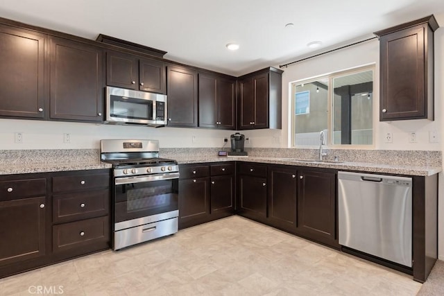 32985 Middlegate Pl, Lake Elsinore, CA 92530 - kitchen featuring appliances with stainless steel finishes, dark brown cabinetry, light floors, and light stone countertops