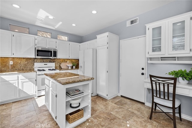 31 Cayman Brac, Aliso Viejo, CA 92656 - kitchen with white appliances, light stone countertops, tasteful backsplash, white cabinets, and open shelves