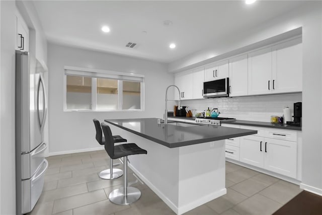 2930 Rowena Ave Unit 4, Los Angeles, CA 90039 - kitchen featuring appliances with stainless steel finishes, dark countertops, a kitchen breakfast bar, decorative backsplash, and recessed lighting
