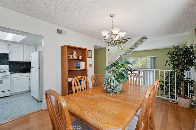 14325 Foothill Blvd Unit 34, Sylmar, CA 91342 - dining room featuring a chandelier, light wood finished floors, and a textured ceiling
