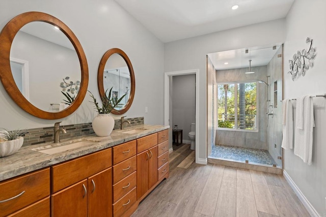 1740 Fire Mountain Dr, Oceanside, CA 92054 - bathroom featuring wood finished floors, a stall shower, double vanity, decorative backsplash, and recessed lighting