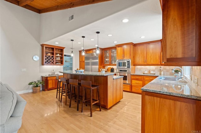 1740 Fire Mountain Dr, Oceanside, CA 92054 - kitchen featuring built in appliances, open shelves, light wood-style flooring, brown cabinets, and a wood ceiling with exposed beams