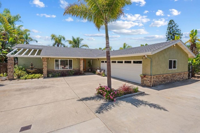 1740 Fire Mountain Dr, Oceanside, CA 92054 - view of front of home with stone siding, stucco siding, concrete driveway, and a garage