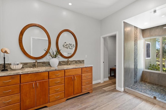 1740 Fire Mountain Dr, Oceanside, CA 92054 - bathroom with double vanity, wood finished floors, decorative backsplash, tiled shower, and recessed lighting