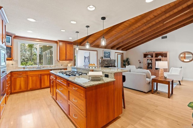 1740 Fire Mountain Dr, Oceanside, CA 92054 - kitchen featuring appliances with stainless steel finishes, light wood-style flooring, backsplash, brown cabinetry, and open floor plan