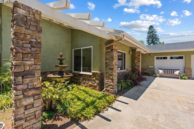 1740 Fire Mountain Dr, Oceanside, CA 92054 - view of property exterior with driveway, stone siding, an attached garage, and stucco siding
