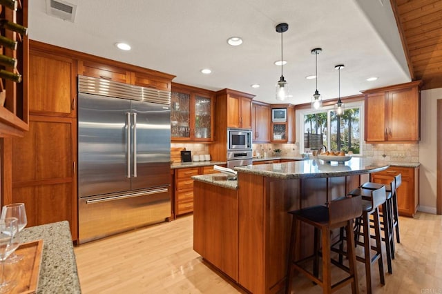 1740 Fire Mountain Dr, Oceanside, CA 92054 - kitchen with built in appliances, brown cabinets, recessed lighting, backsplash, and light wood finished floors