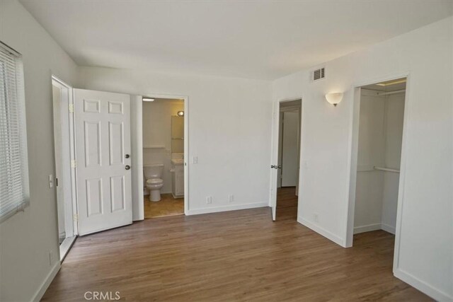 1138 N Valley St, Burbank, CA 91505 - unfurnished bedroom featuring a walk in closet, wood finished floors, and connected bathroom