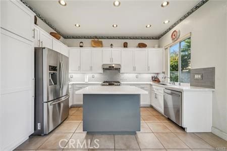 14213 Aliso Ct, Chino Hills, CA 91709 - kitchen with stainless steel appliances, under cabinet range hood, light countertops, a kitchen island, and white cabinetry
