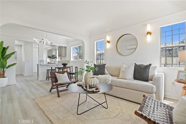 215 E 107th St, Los Angeles, CA 90003 - living area with wood finished floors, arched walkways, and a chandelier