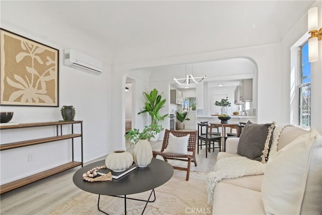 215 E 107th St, Los Angeles, CA 90003 - living area featuring arched walkways, an AC wall unit, wood finished floors, and a chandelier