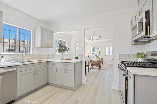 215 E 107th St, Los Angeles, CA 90003 - kitchen featuring appliances with stainless steel finishes, gray cabinets, light wood finished floors, and light countertops