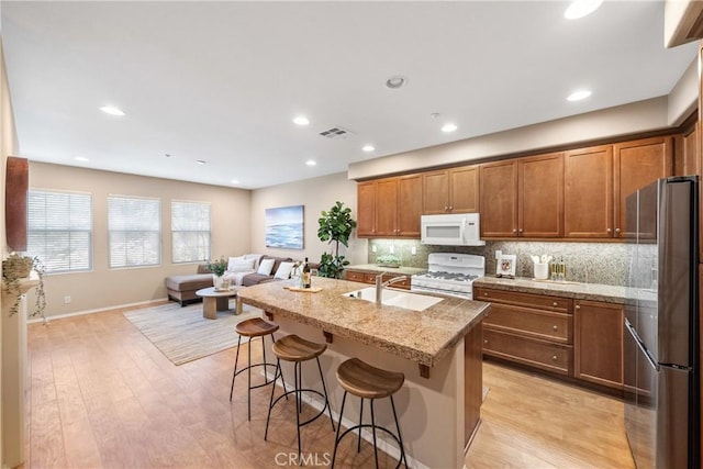 118 Vintage Unit 18, Irvine, CA 92620 - kitchen featuring white appliances, brown cabinets, a kitchen breakfast bar, light wood finished floors, and decorative backsplash