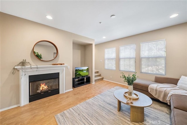 118 Vintage Unit 18, Irvine, CA 92620 - living room with wood finished floors, a glass covered fireplace, stairway, and recessed lighting