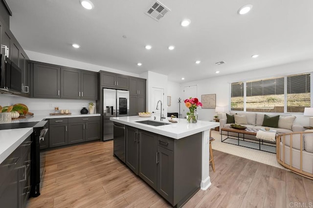 766 Makani St Unit 1, Chula Vista, CA 91911 - kitchen with black appliances, light countertops, open floor plan, light wood-type flooring, and recessed lighting
