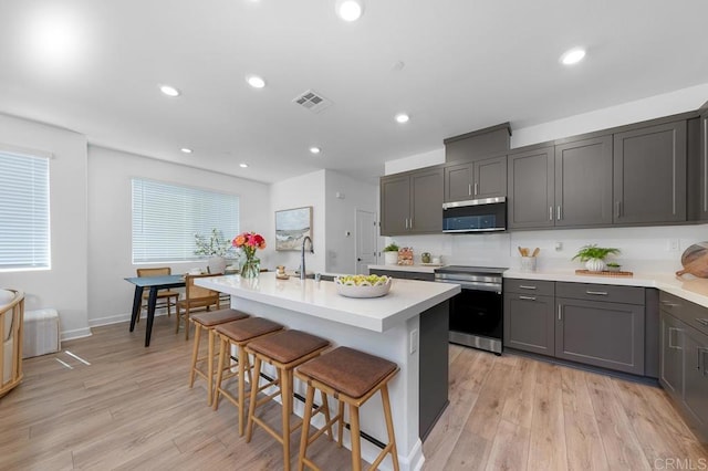 766 Makani St Unit 1, Chula Vista, CA 91911 - kitchen featuring stainless steel appliances, a breakfast bar area, light countertops, light wood-style floors, and recessed lighting