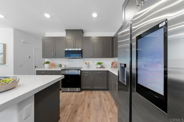 766 Makani St Unit 1, Chula Vista, CA 91911 - kitchen with appliances with stainless steel finishes, light countertops, gray cabinets, light wood finished floors, and recessed lighting